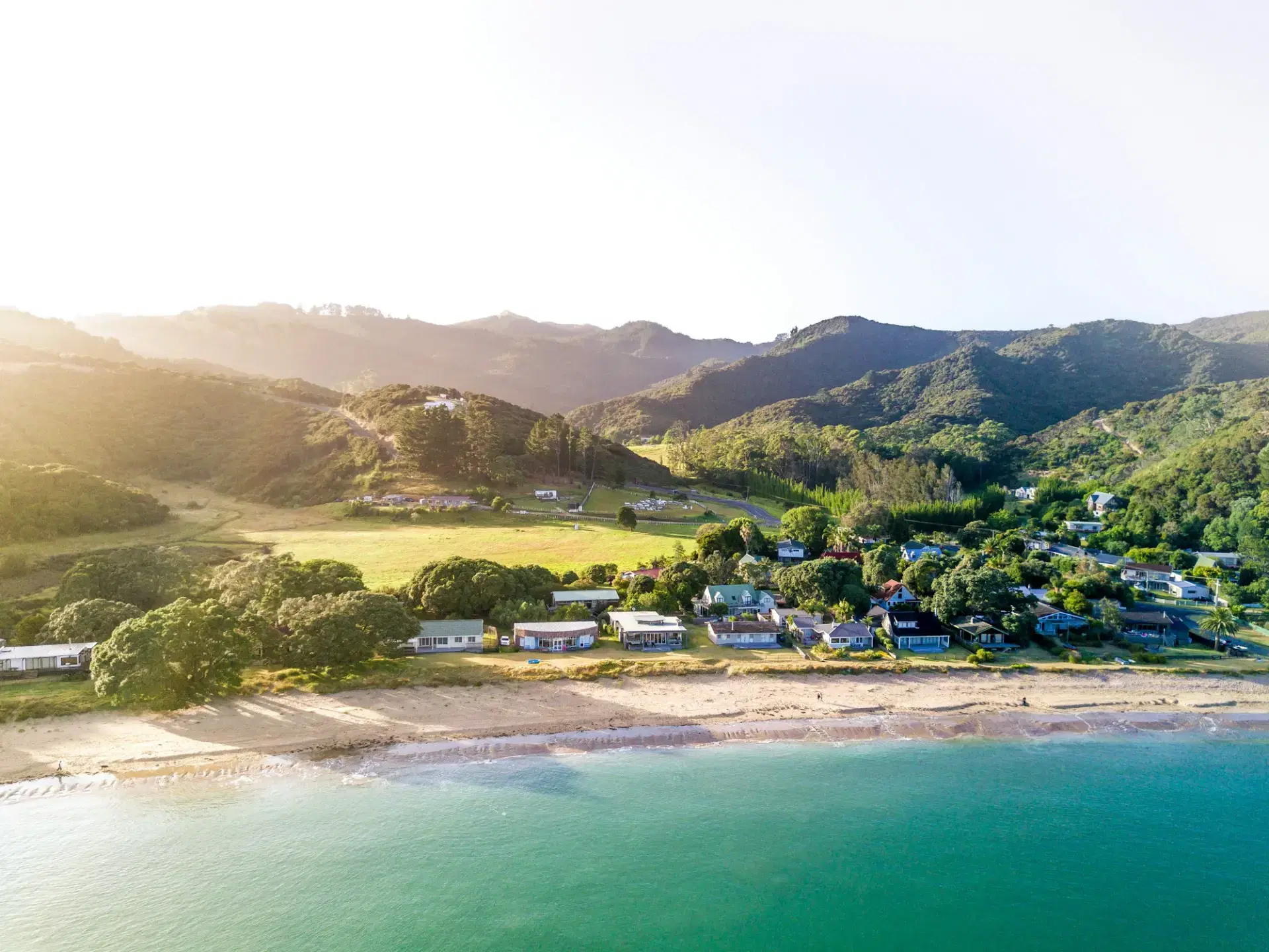Aerial view of a turquoise New Zealand lake beneath mountains