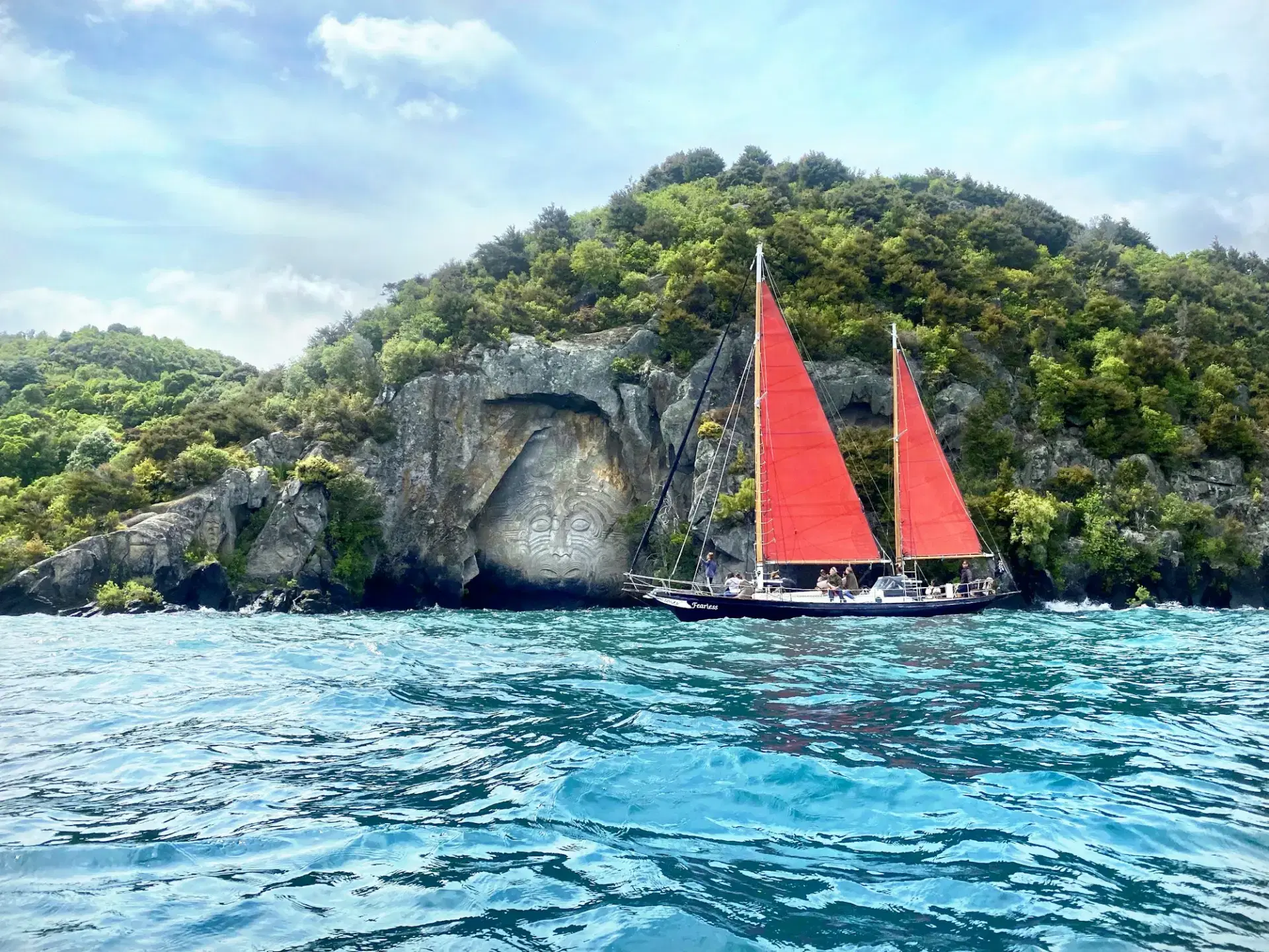 Sailboat on Lake Taupo with mountains beyond