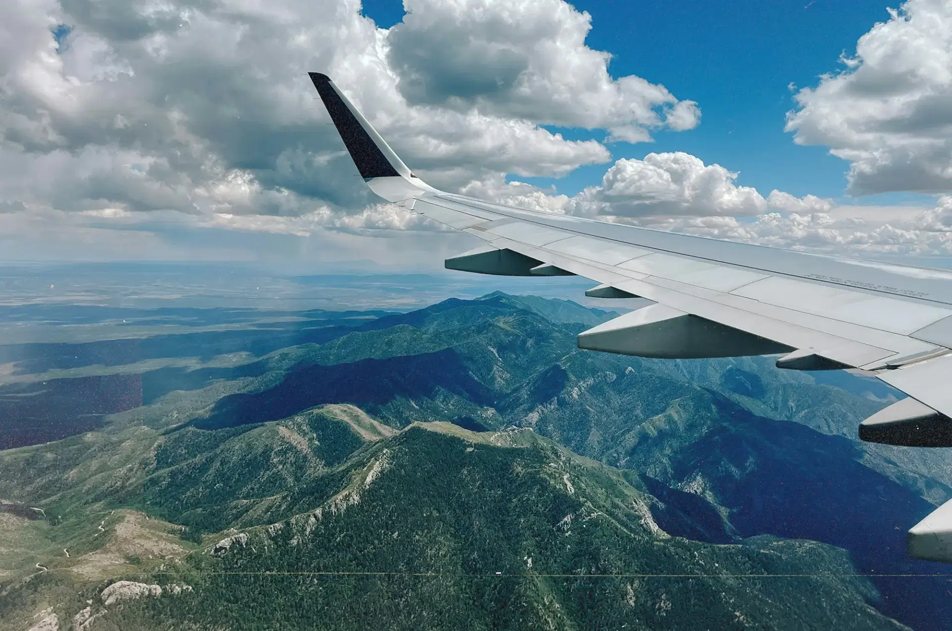 Aeroplane wing flying over a mountain range